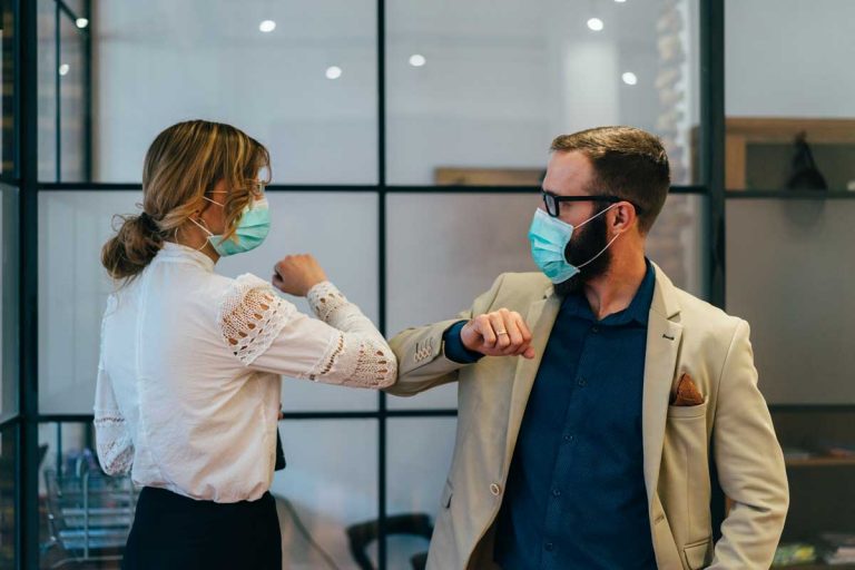 coworkers in office working distantly with masks
